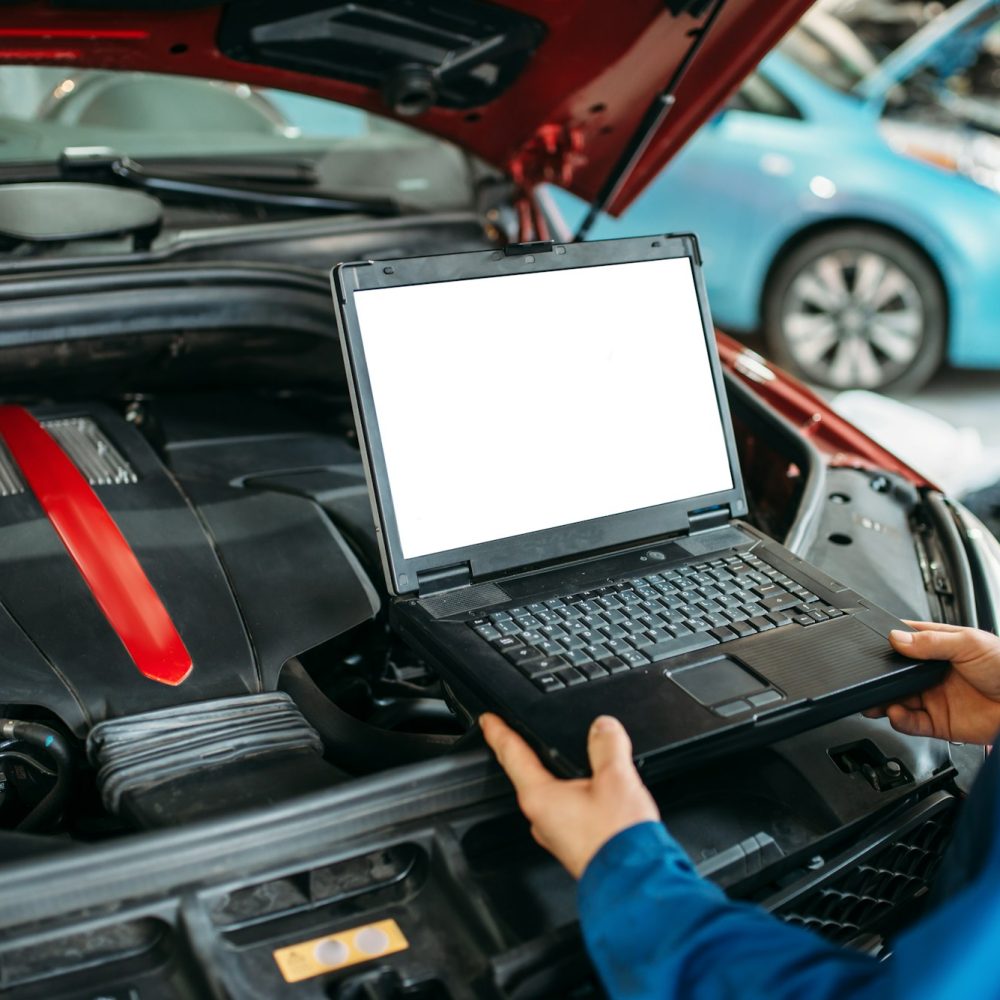 Engineer makes computer diagnostics of car engine