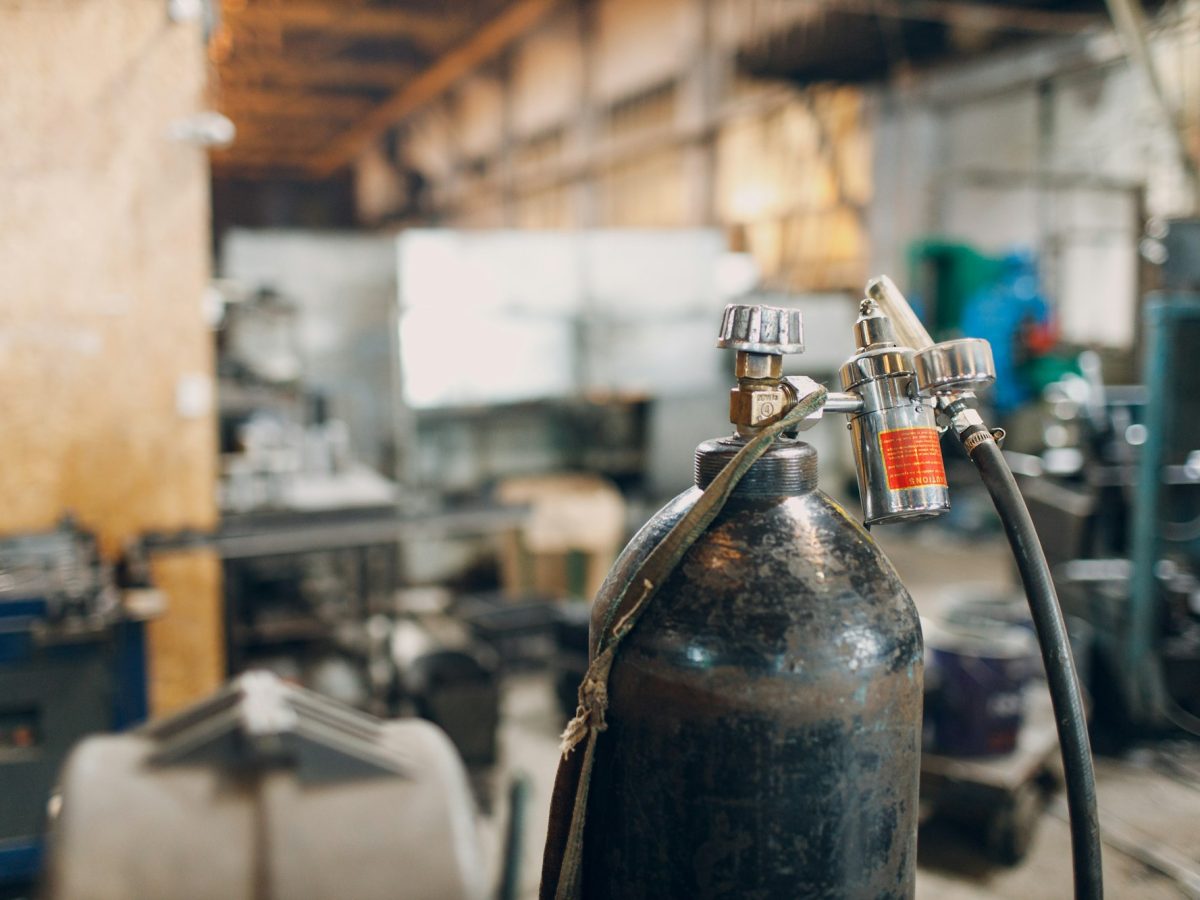 Iron gas cylinder for welding products on factory background.