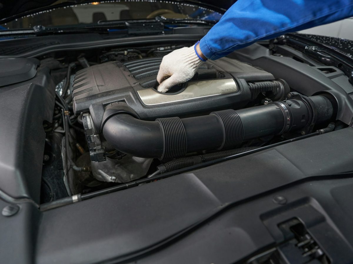 Male performing car maintenance at service station