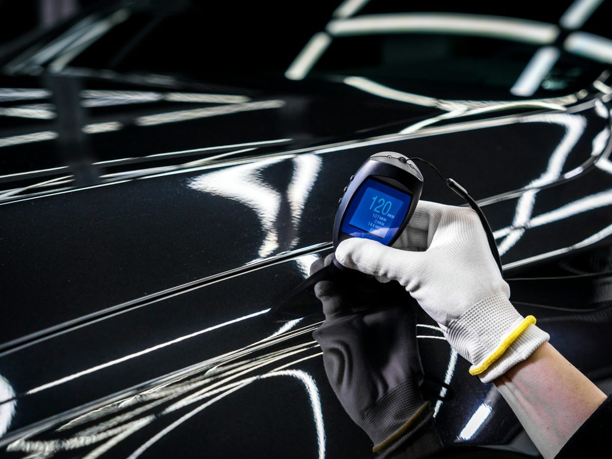 Measuring the thickness of a car paint coating with a thickness gauge