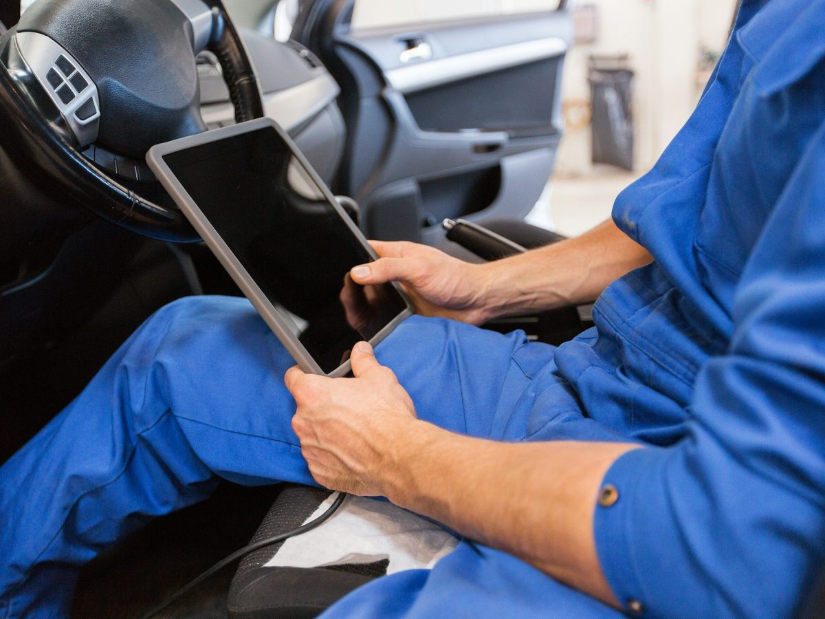 mechanic man with tablet pc making car diagnostic